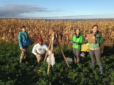people with scientific equipment in an agricultural field