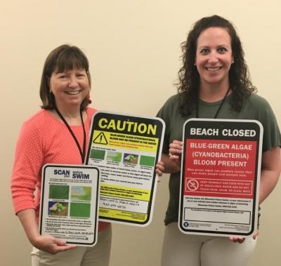 two women holding three signs