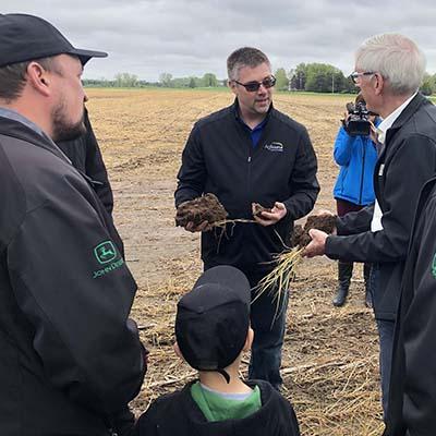 Nick Guilette talking to people in a crop field.