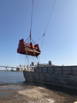 dredging equipment being hoisted out of the water