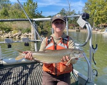 A Biologist holding a lake trout. 
