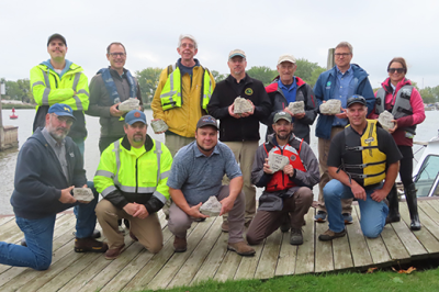 Group of project partners holding signed rocks to show support for new Channel Island Reef 