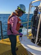 An EPA scientist collects a water sample aboard the R/V Lake Guardian in Lake Michigan during the 2022 EPA Summer Survey of Great Lakes water quality and biology.